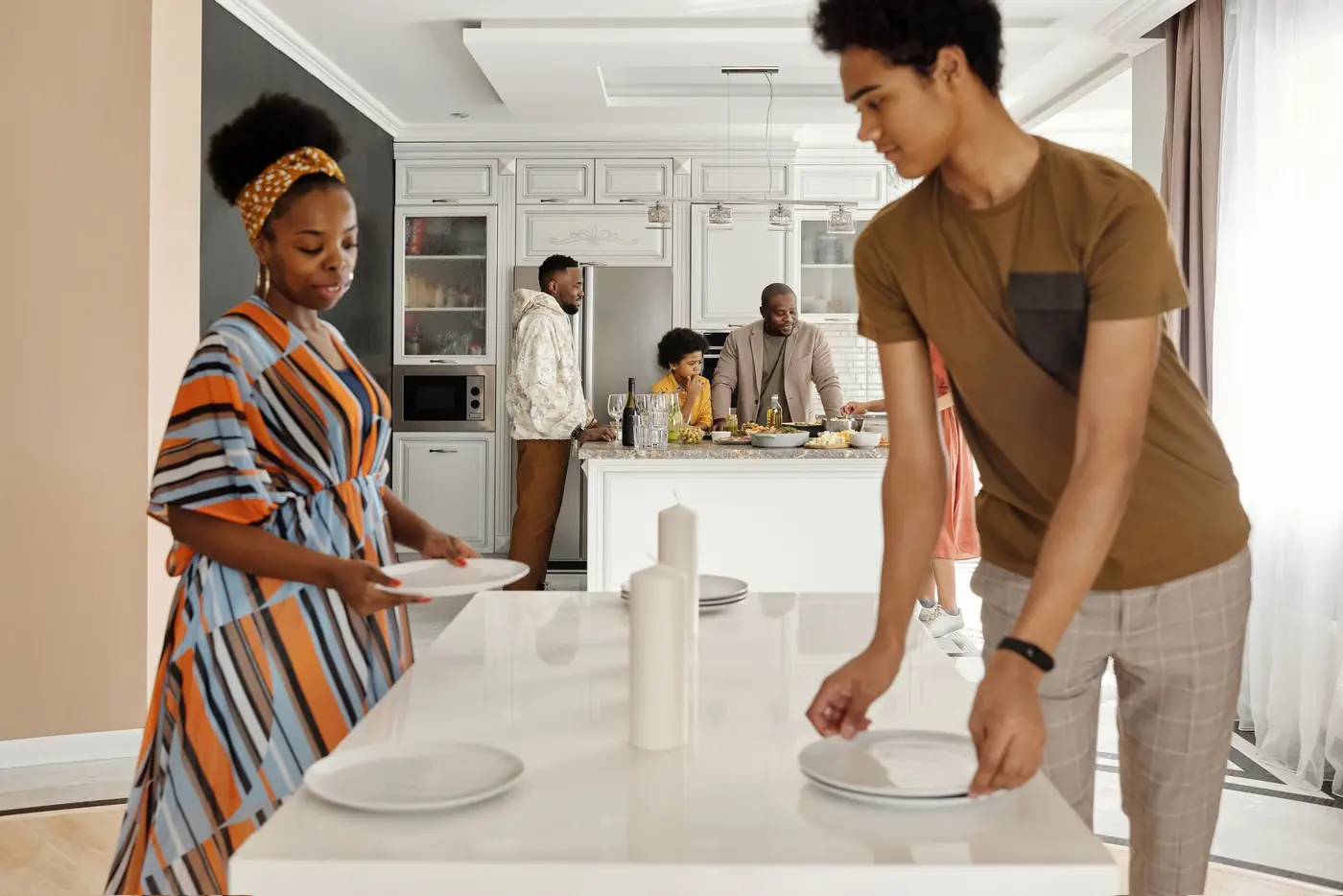 An adult and a teenager setting the table together