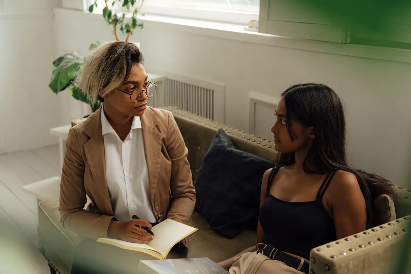 A counsellor listening closely to a teenage girl